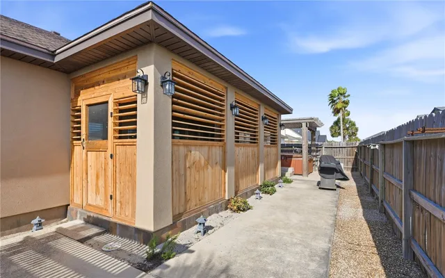 a view of a patio with a table and chairs and wooden fence