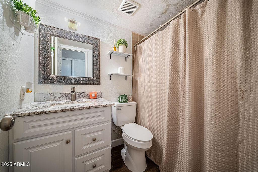 4233 North 68th Avenue Phoenix, AZ 85033 - Photo 4 of 11 a bathroom with a granite countertop sink toilet and mirror