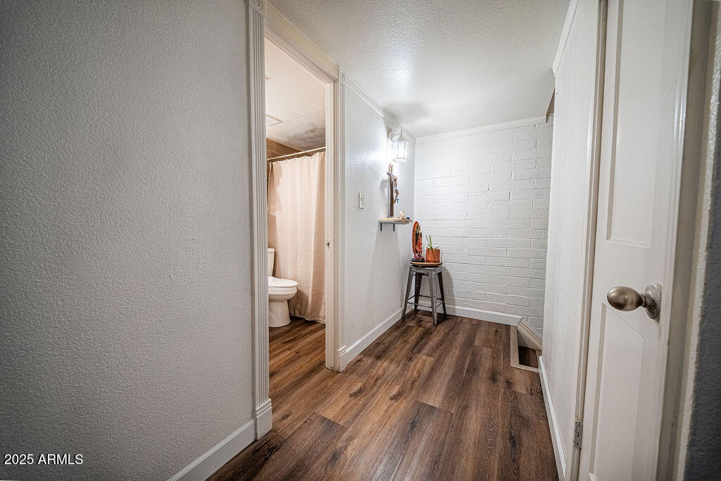 4233 North 68th Avenue Phoenix, AZ 85033 - Photo 7 of 11 a view of a hallway with wooden floor and a bathroom