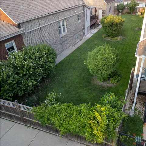 a aerial view of a house with a yard and potted plants