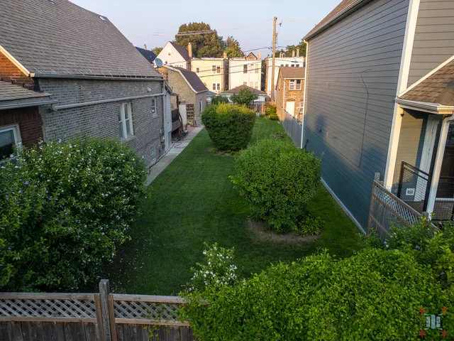 a view of a house with a backyard and plants