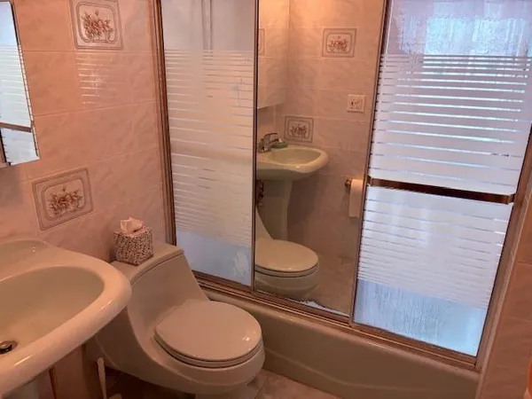 a white toilet sitting next to a bathroom sink