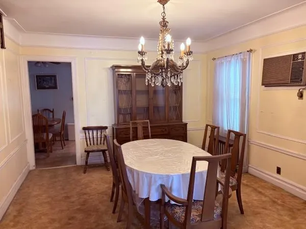 a view of a dining room with furniture and chandelier