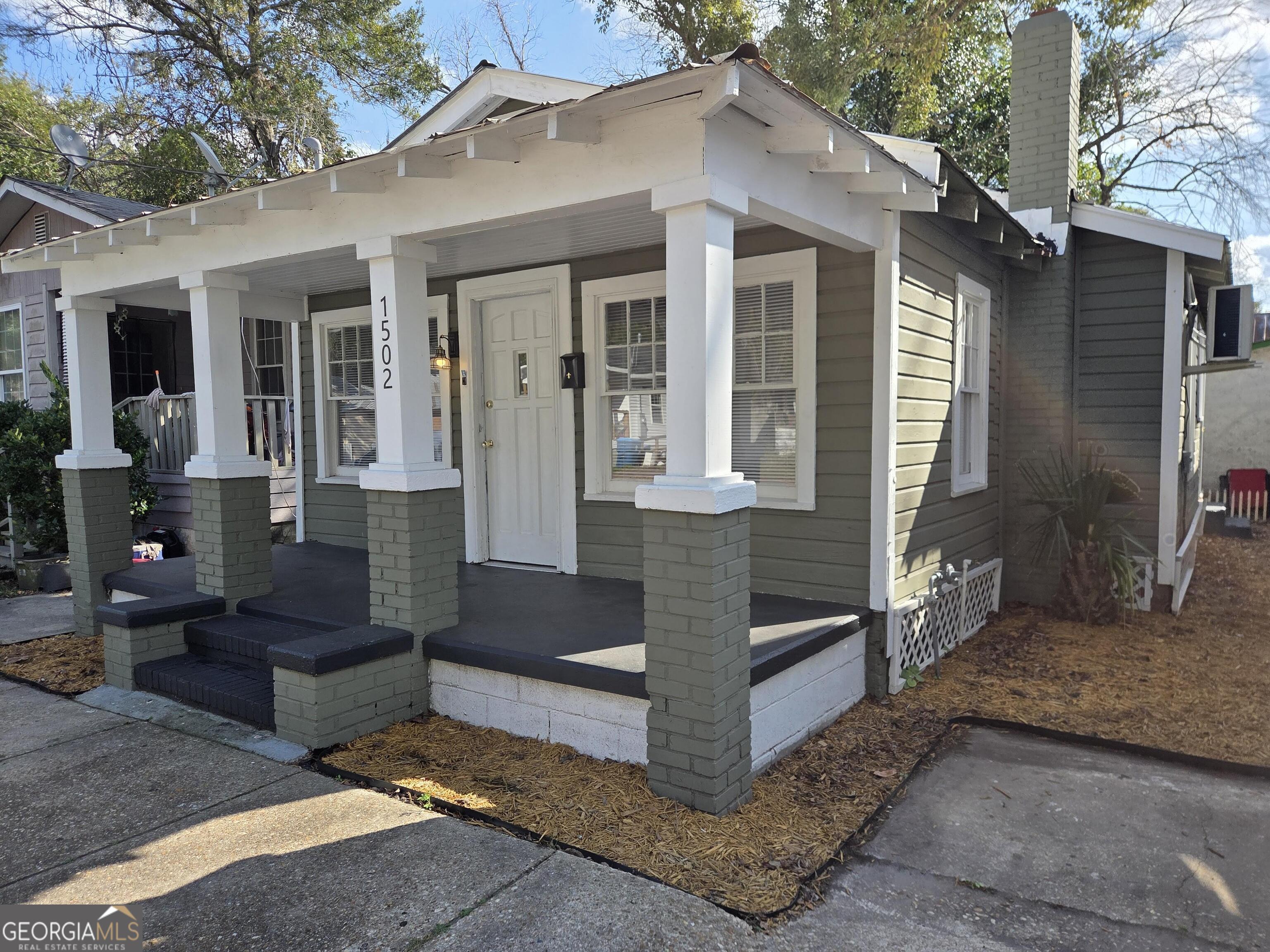 1502 Monck Street Brunswick, GA 31520 - Photo 3 of 32 a view of a house with a large tree and wooden fence