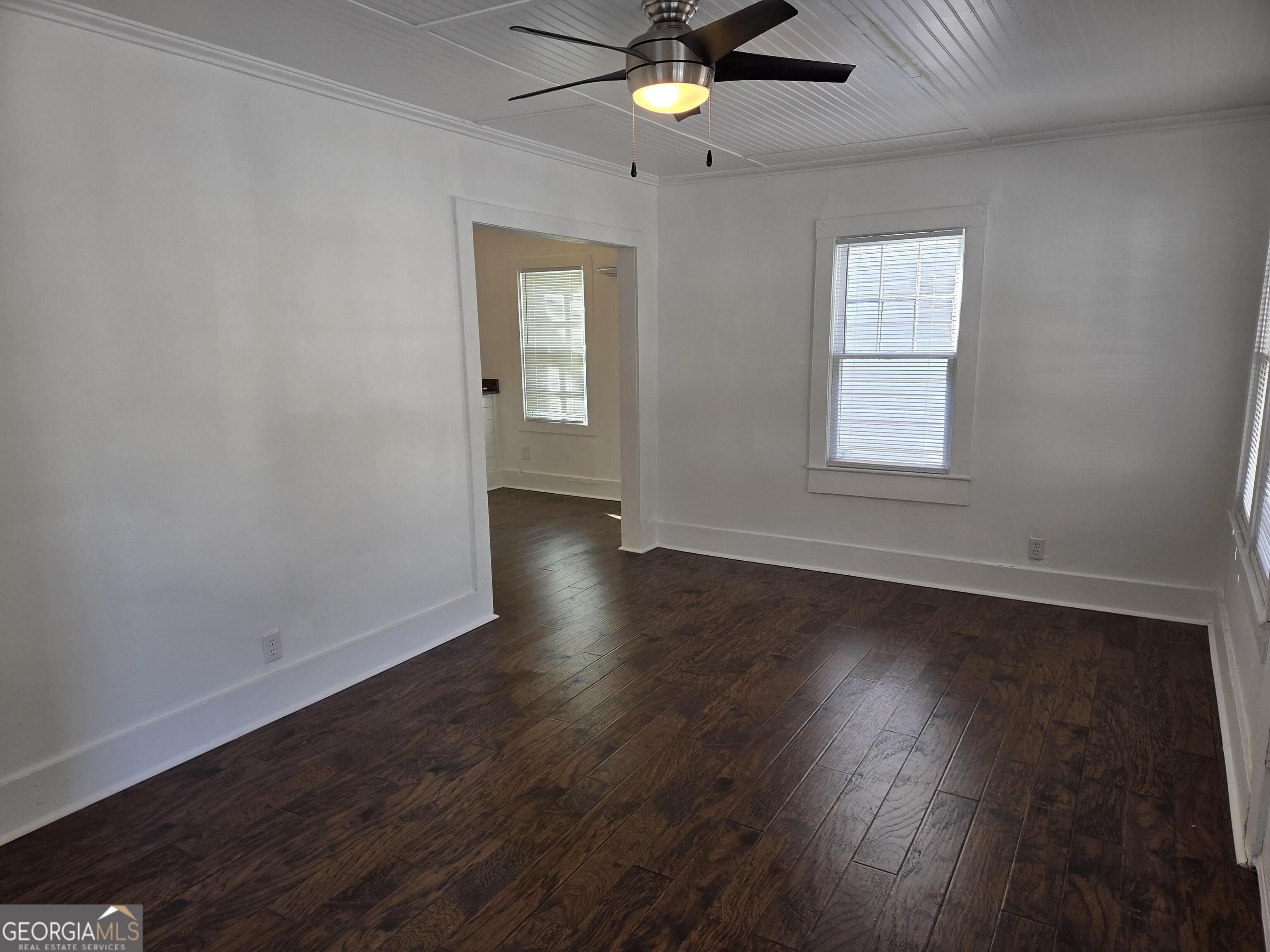 1502 Monck Street Brunswick, GA 31520 - Photo 4 of 32 an empty room with wooden floor chandelier fan and windows