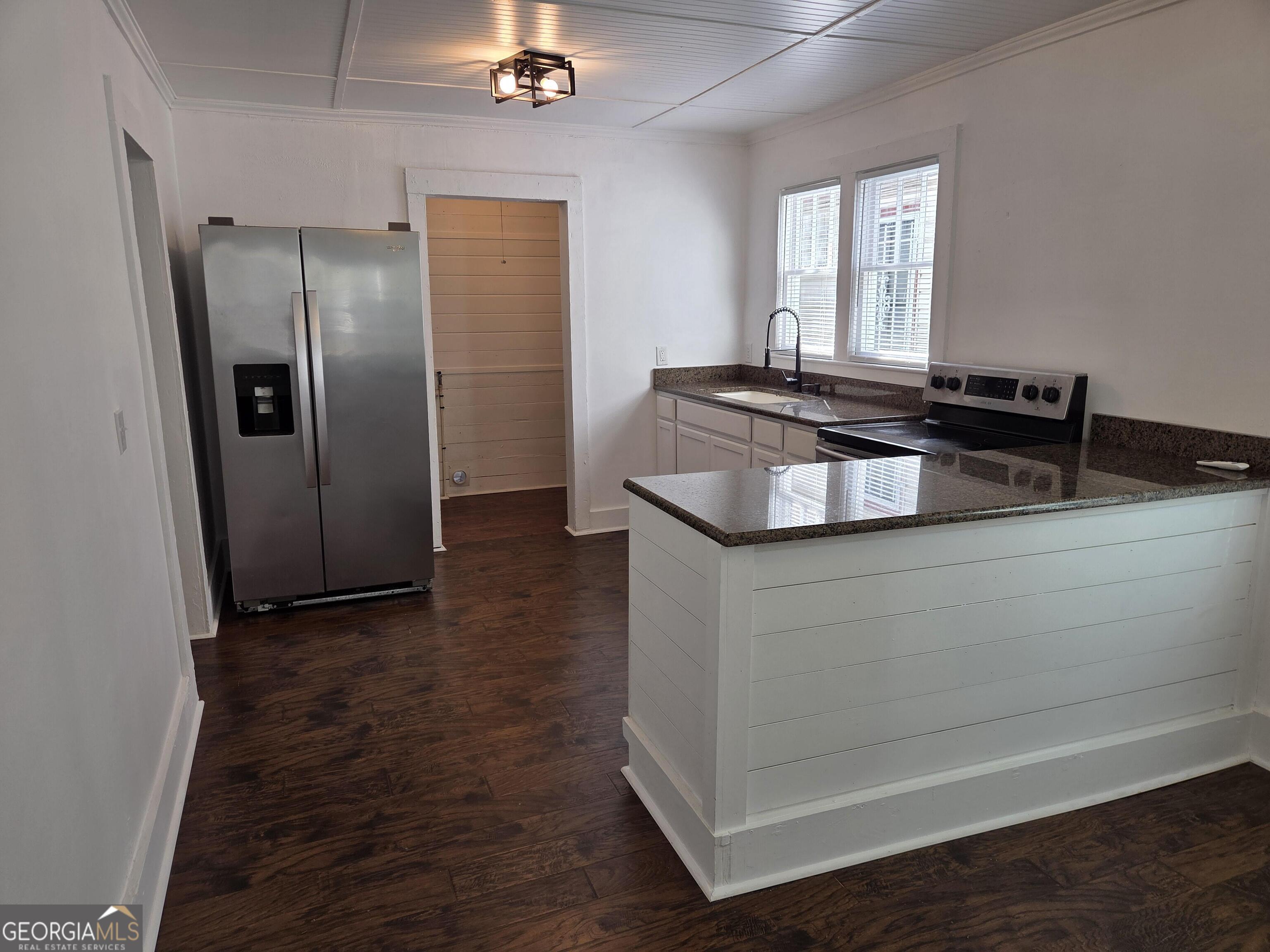 1502 Monck Street Brunswick, GA 31520 - Photo 8 of 32 a kitchen with granite countertop a refrigerator and a sink