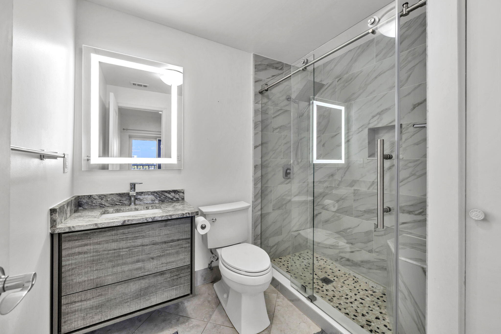 195 Durango Road, Unit 3A Destin, FL 32541 - Photo 11 of 41 a bathroom with a granite countertop toilet a sink a mirror and shower