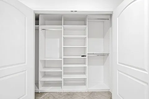 a view of walk in closet with empty racks