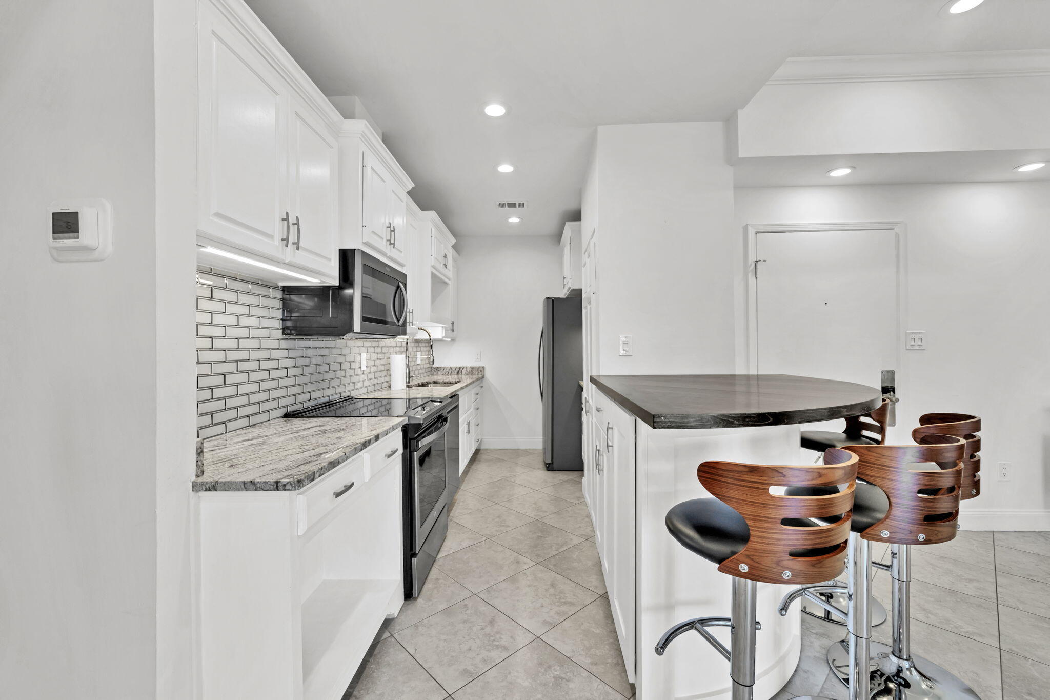 195 Durango Road, Unit 3A Destin, FL 32541 - Photo 20 of 41 a kitchen with stainless steel appliances granite countertop a stove a sink a refrigerator and a microwave