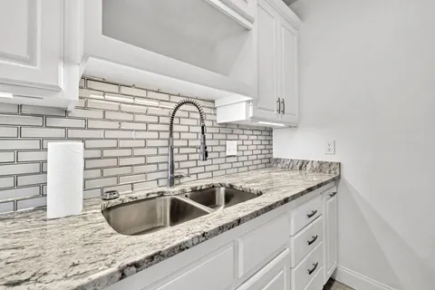 a kitchen with granite countertop a sink and a stove