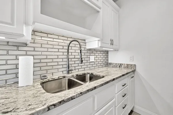 a kitchen with granite countertop a sink and a stove
