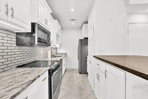 a kitchen with stainless steel appliances granite countertop a sink and a stove