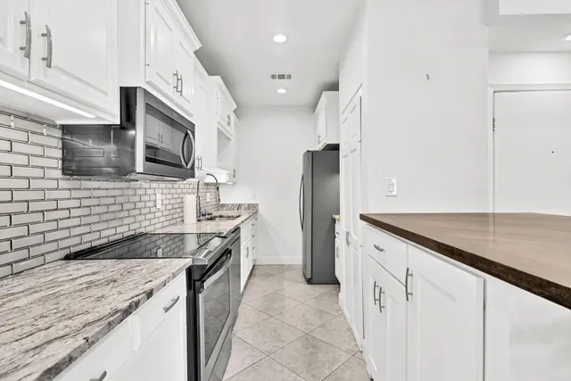 a kitchen with stainless steel appliances granite countertop a sink and a stove
