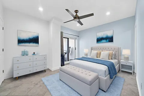 a spacious bedroom with a bed and a flat screen tv