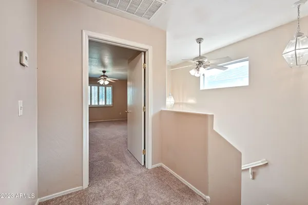 a view of a hallway with wooden floor and a living room