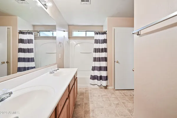 a en suite bathroom with a sink mirror and shower
