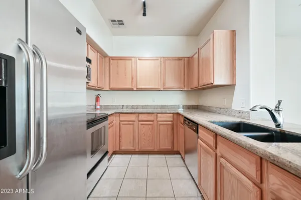 a kitchen with stainless steel appliances granite countertop a sink and a refrigerator