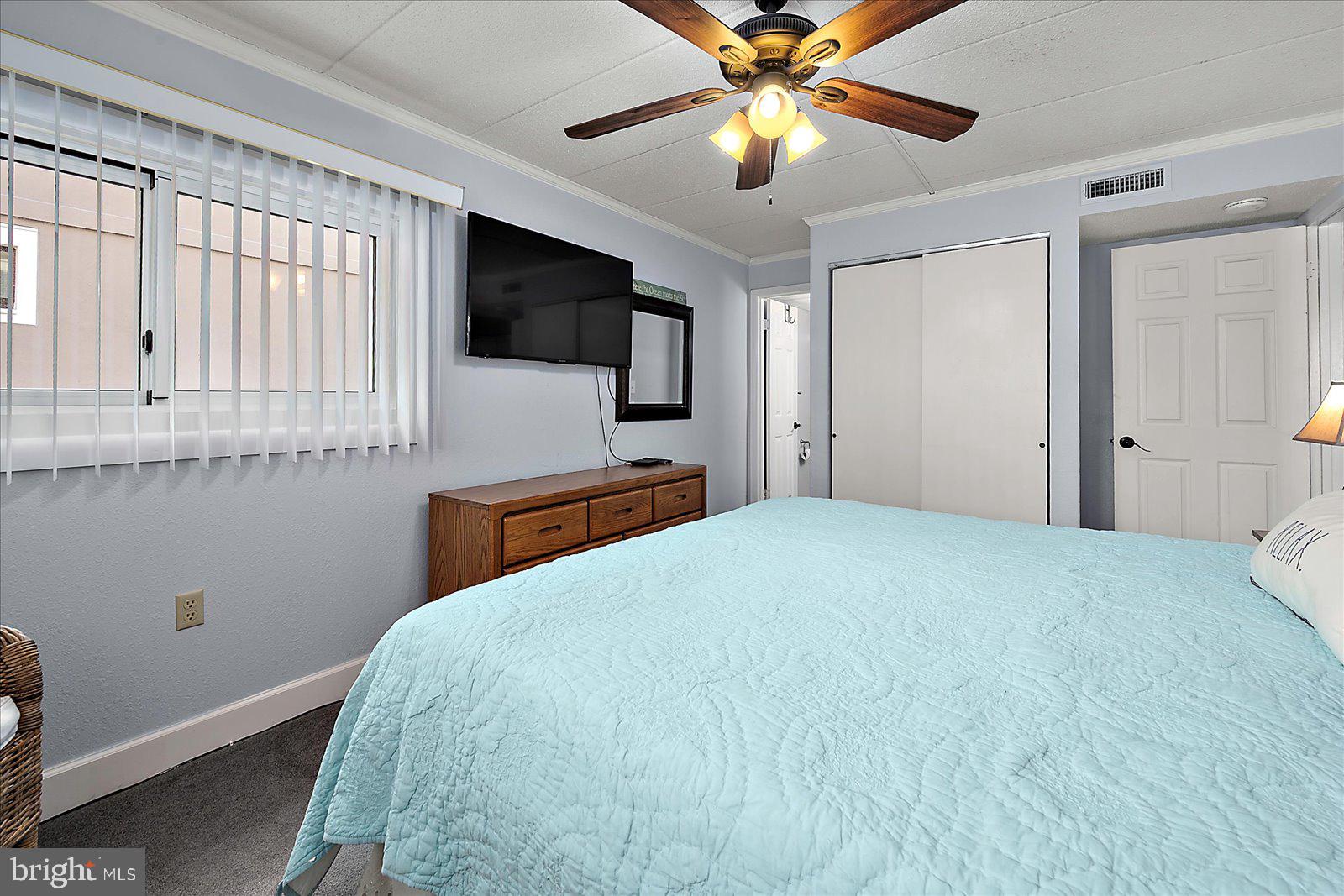 4 46th Street, Unit 101 Ocean City, MD 21842 - Photo 13 of 27 a bedroom with a large bed and a flat tv screen