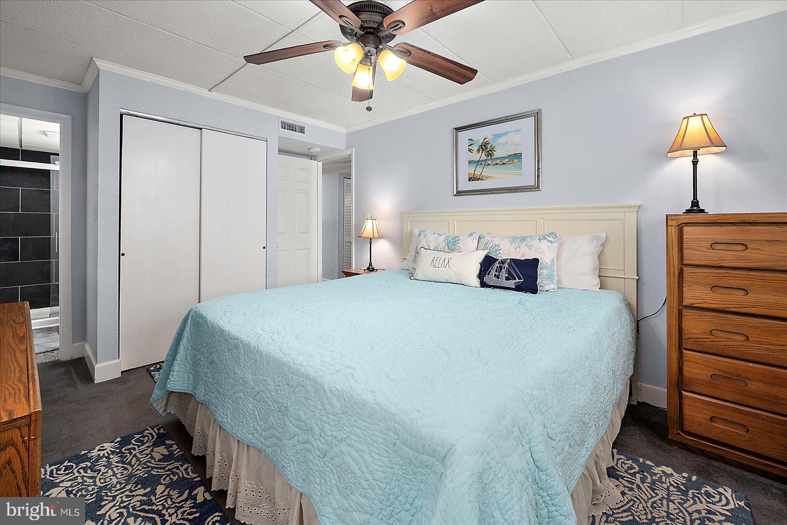 4 46th Street, Unit 101 Ocean City, MD 21842 - Photo 14 of 27 a bedroom with a bed and a chandelier
