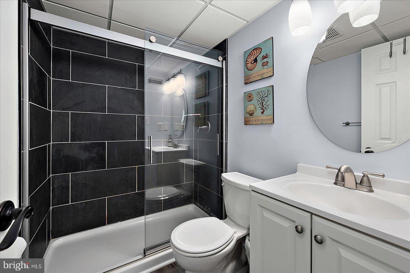 4 46th Street, Unit 101 Ocean City, MD 21842 - Photo 15 of 27 a bathroom with a toilet a sink and mirror