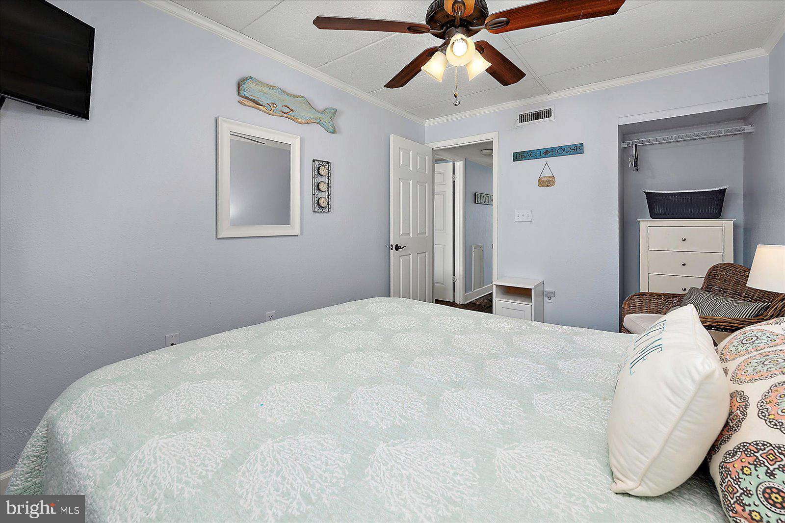 4 46th Street, Unit 101 Ocean City, MD 21842 - Photo 18 of 27 a bedroom with a large bed and a flat tv screen on a dresser