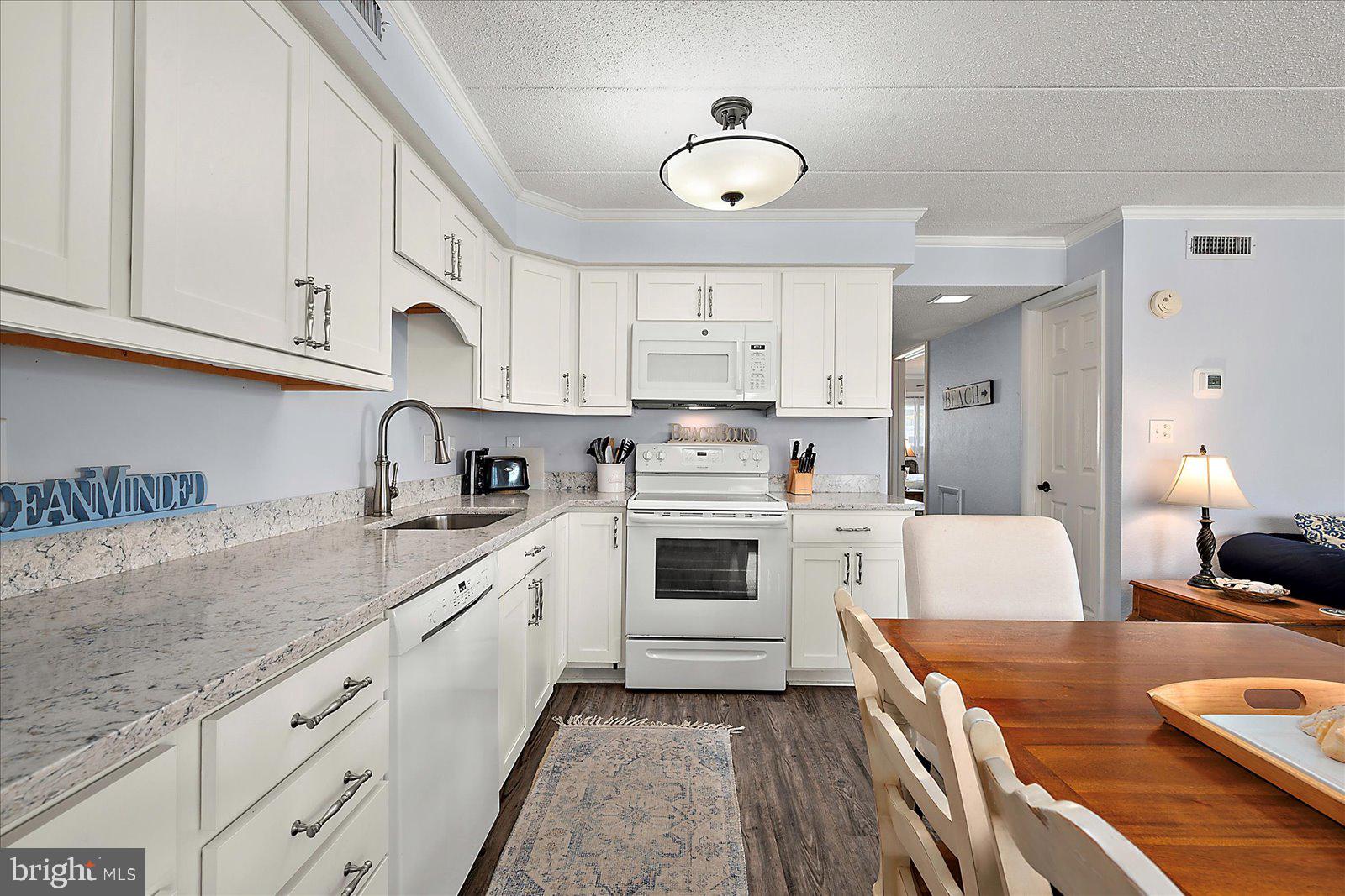 4 46th Street, Unit 101 Ocean City, MD 21842 - Photo 9 of 27 a kitchen with granite countertop a sink stainless steel appliances and cabinets