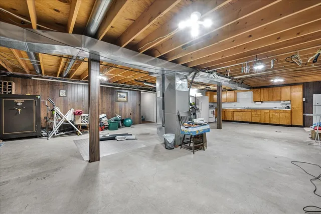 a kitchen with stainless steel appliances granite countertop a stove top oven a refrigerator a sink and dishwasher with wooden floor