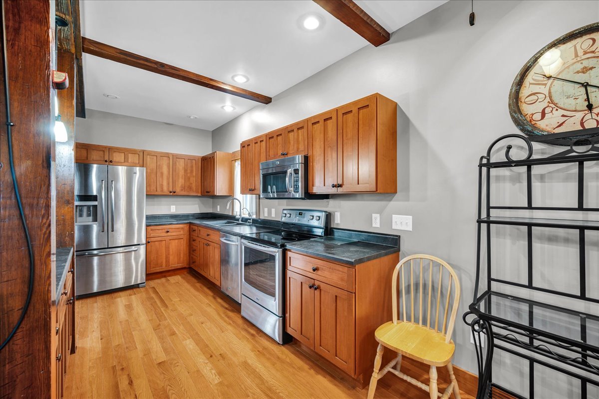 708 North 1950th Road Tonica, IL 61370 - Photo 41 of 95 a kitchen with stainless steel appliances granite countertop a stove top oven a refrigerator a sink and dishwasher with wooden floor