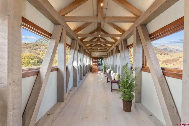 a living room with furniture a fireplace and a floor to ceiling window