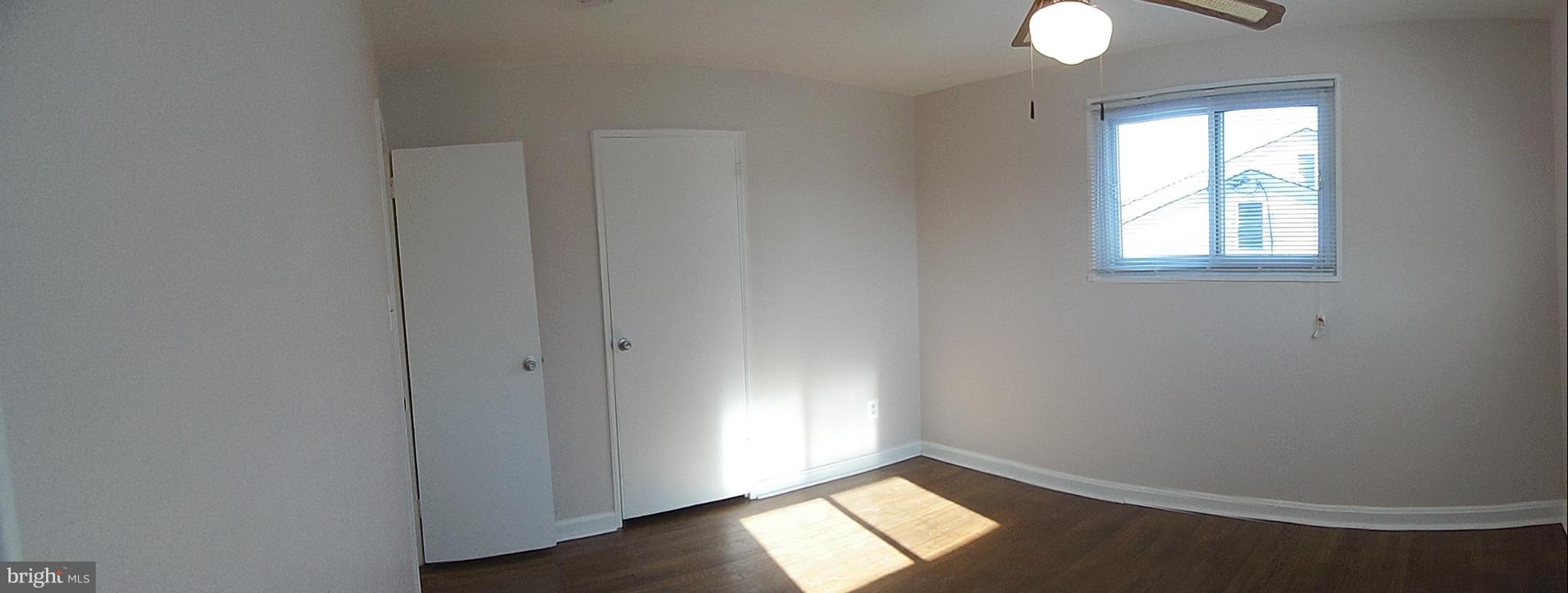 1303 Ray Road Hyattsville, MD 20782 - Photo 11 of 17 an empty room with wooden floor cabinet and windows