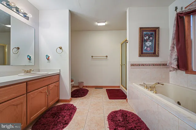 a bathroom with a tub sink and mirror
