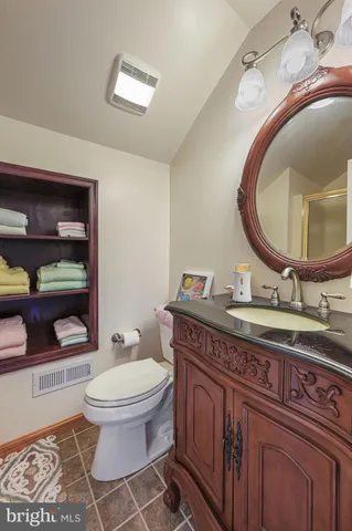 a bathroom with a toilet a sink and mirror