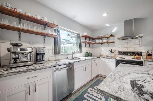a kitchen with stainless steel appliances granite countertop a refrigerator and a stove top oven