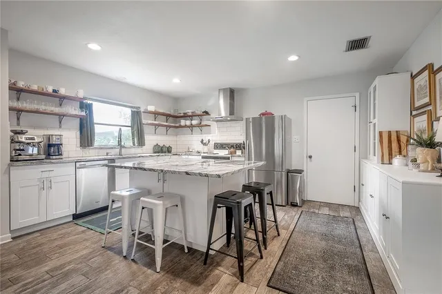 a large white kitchen with sink and white cabinets
