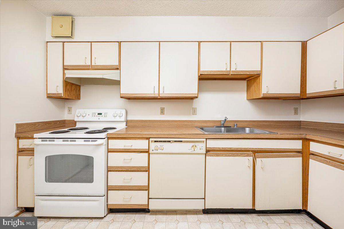 15101 Interlachen Drive, Unit 1807 Silver Spring, MD 20906 - Photo 23 of 50 a kitchen with white cabinets and white appliances