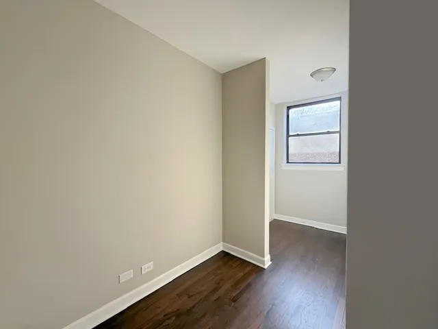 an empty room with wooden floor and closet