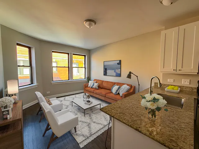 a kitchen with granite countertop a sink and white cabinets