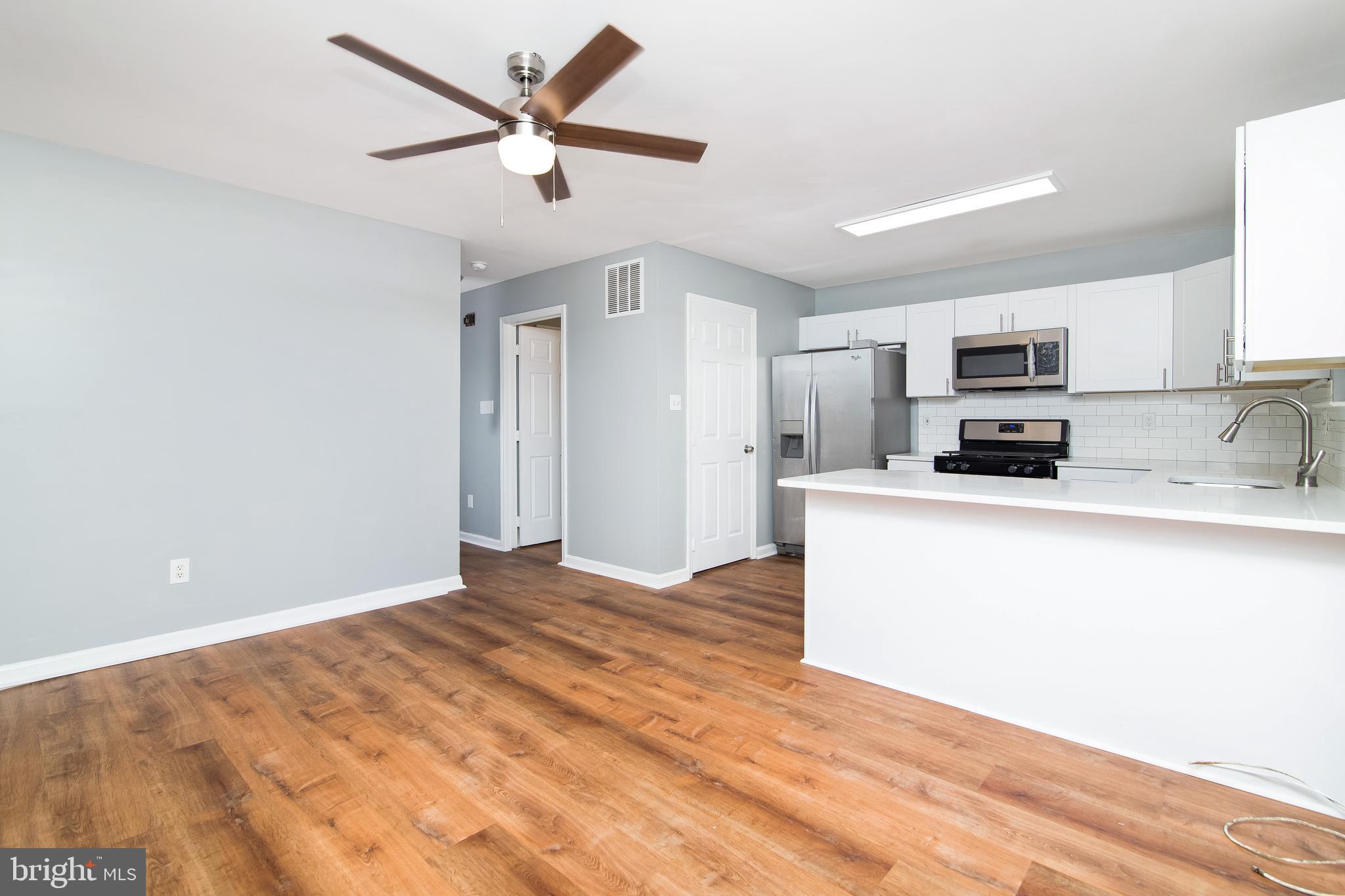 20 Gristmill Lane Pine Hill, NJ 08021 - Photo 6 of 37 a kitchen with granite countertop a refrigerator a stove a microwave oven a sink with dishwasher and white cabinets