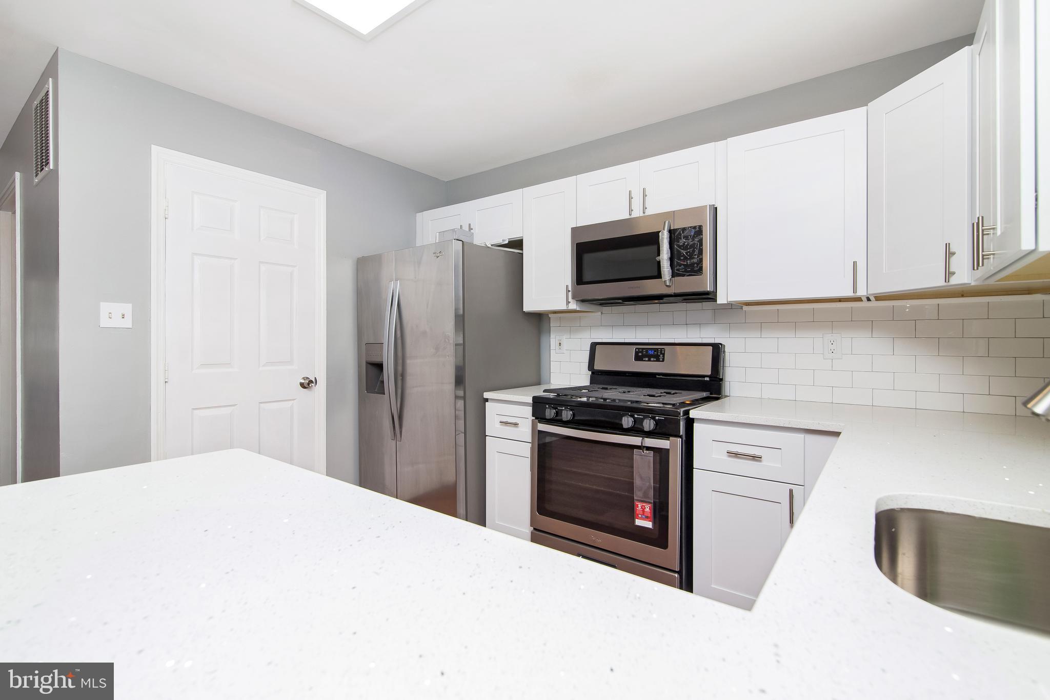 20 Gristmill Lane Pine Hill, NJ 08021 - Photo 8 of 37 a kitchen with stainless steel appliances granite countertop a stove a microwave and a refrigerator