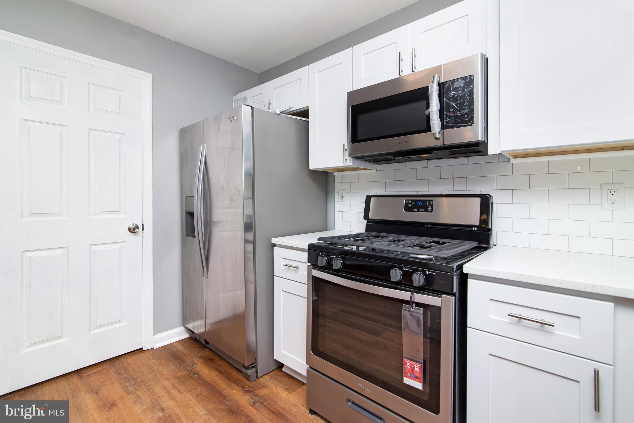 20 Gristmill Lane Pine Hill, NJ 08021 - Photo 9 of 37 a kitchen with stainless steel appliances a stove a microwave and cabinets
