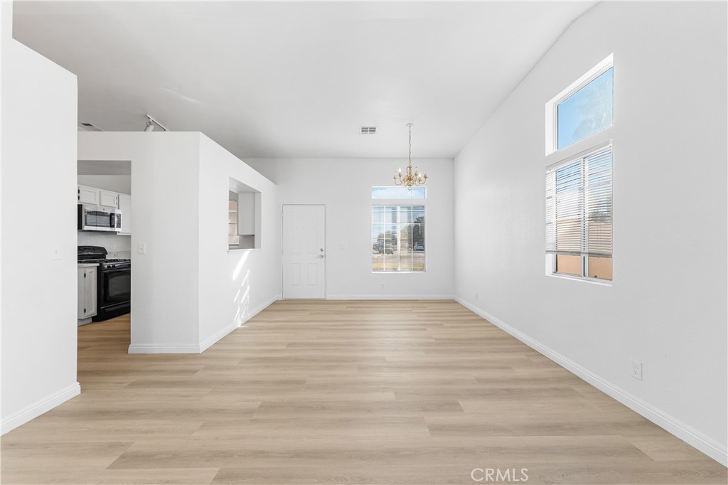 3209 Titcher Lane Rosamond, CA 93560 - Photo 14 of 36 a view of an empty room with a window and wooden floor