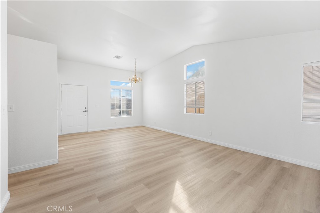 3209 Titcher Lane Rosamond, CA 93560 - Photo 15 of 36 an empty room with wooden floor and windows