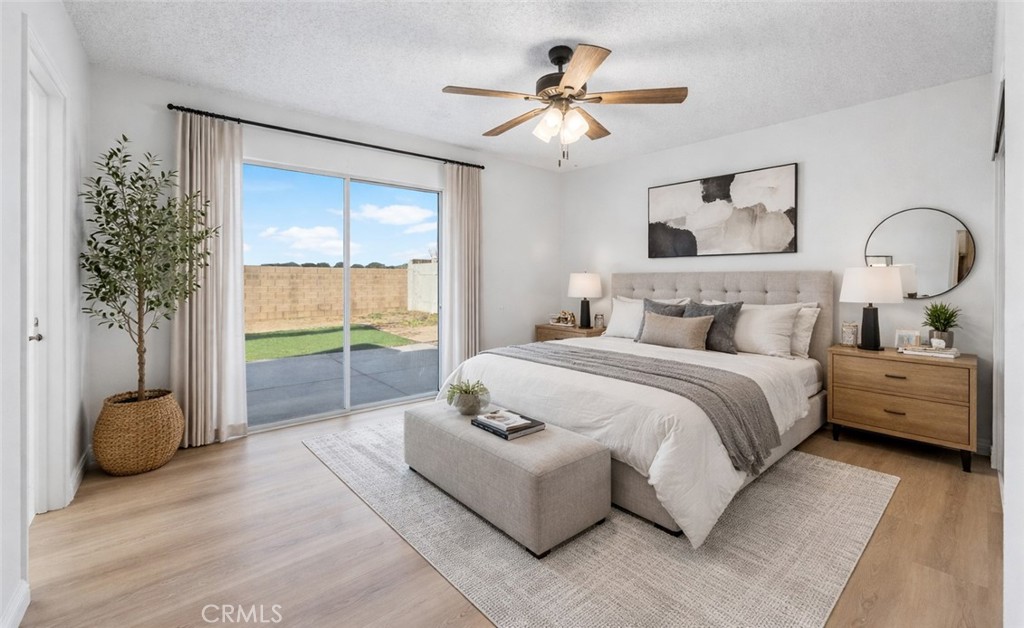 3209 Titcher Lane Rosamond, CA 93560 - Photo 22 of 36 a bedroom with a large bed and a chandelier