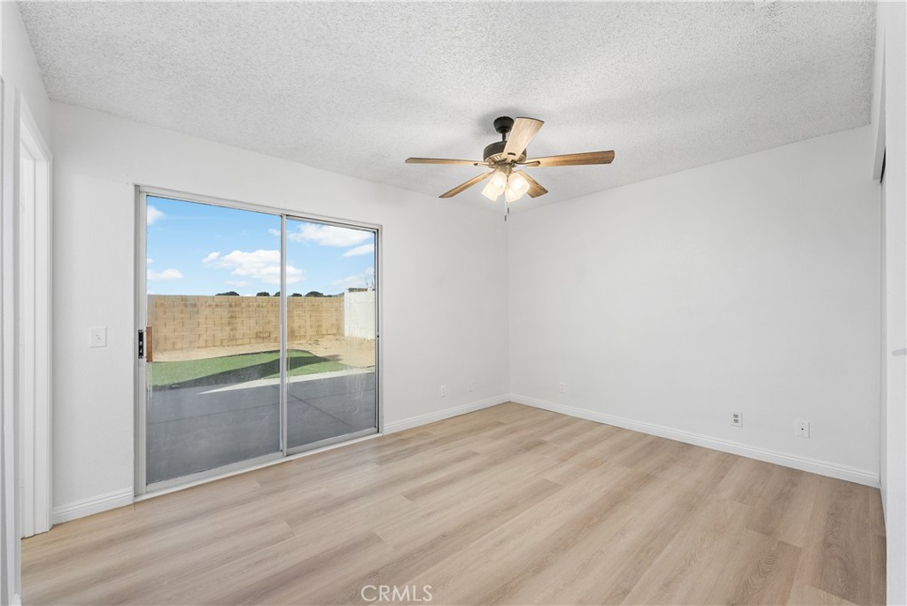 3209 Titcher Lane Rosamond, CA 93560 - Photo 23 of 36 an empty room with a window and a ceiling fan