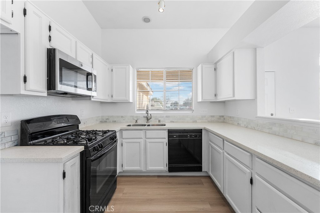 3209 Titcher Lane Rosamond, CA 93560 - Photo 7 of 36 a kitchen with stainless steel appliances granite countertop a stove a sink and a microwave