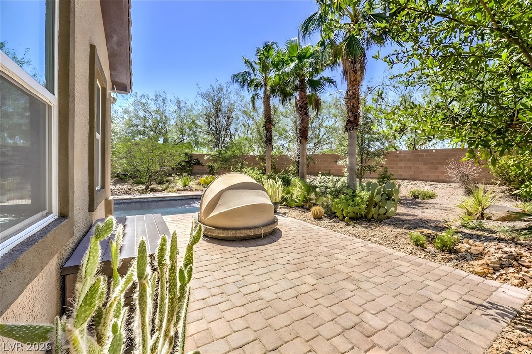 7119 Arabian Ridge Street Las Vegas, NV 89131 - Photo 53 of 73 A desert oasis with a paved patio, lush landscaping, and a refreshing pool.