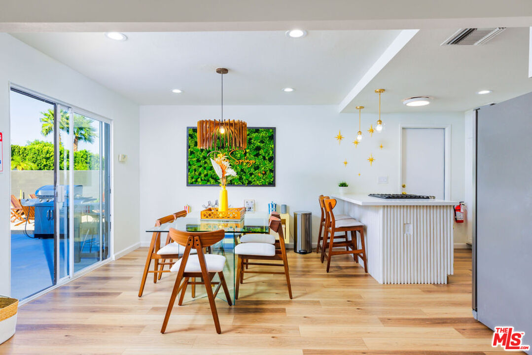 1250 East Delgado Road Palm Springs, CA 92262 - Photo 7 of 30 a view of a kitchen with kitchen island stainless steel appliances wooden floor dining table and chair