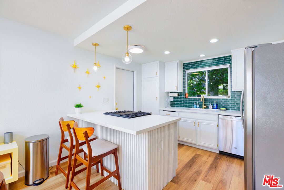 1250 East Delgado Road Palm Springs, CA 92262 - Photo 9 of 30 a kitchen with stainless steel appliances granite countertop a sink a stove a refrigerator a microwave oven with a dining table and chairs