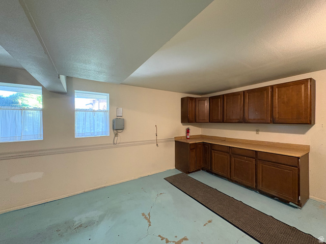 595 Meadowlark Road Orem, UT 84097 - Photo 68 of 87 Utility room featuring multiple windows, extensive built-in cabinetry, and a spacious countertop