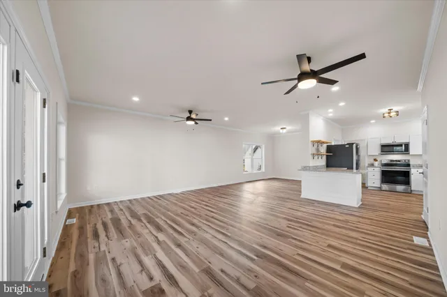 a large kitchen with stainless steel appliances kitchen island granite countertop a refrigerator and a sink